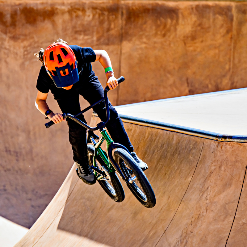 Person riding a BMX bike on a wooden ramp