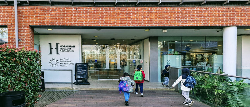 Children with backpacks walking towards a building entrance with 'Horniman Museum' signage.
