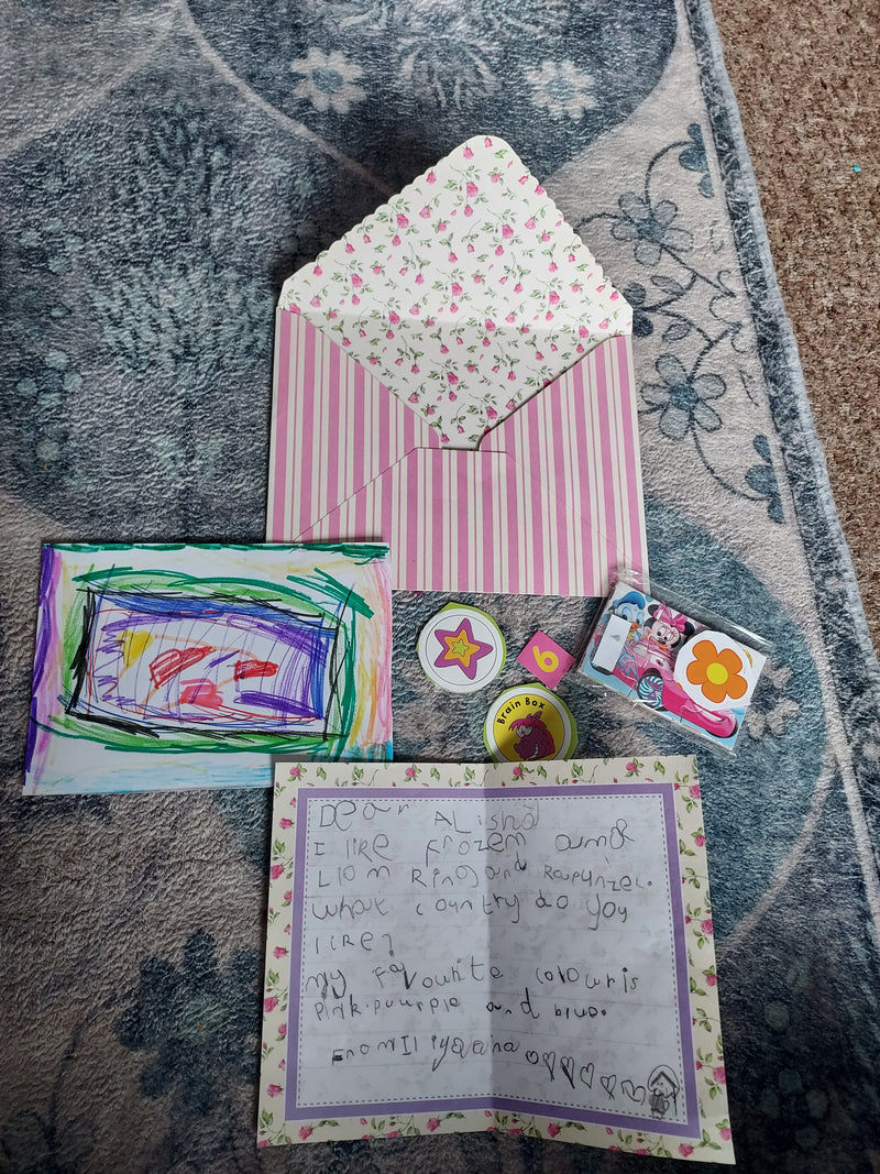 Stationery items including an envelope, cards, and a letter on a textured surface.