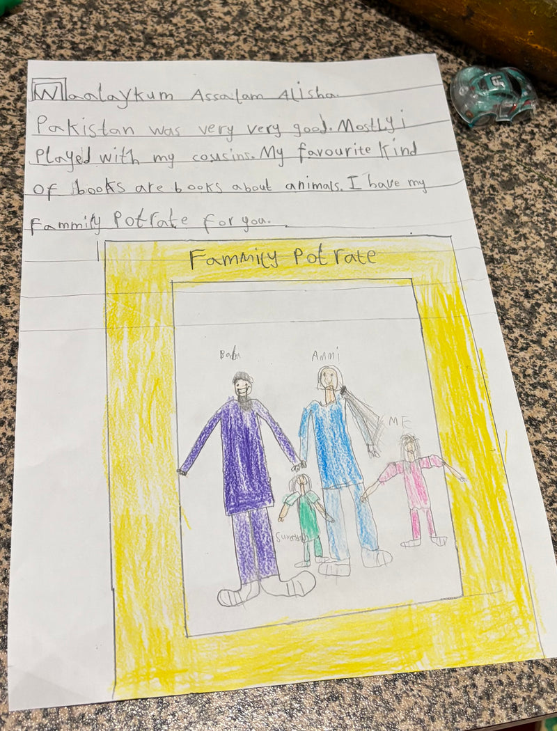 Child's drawing of a family portrait with text on a piece of paper.